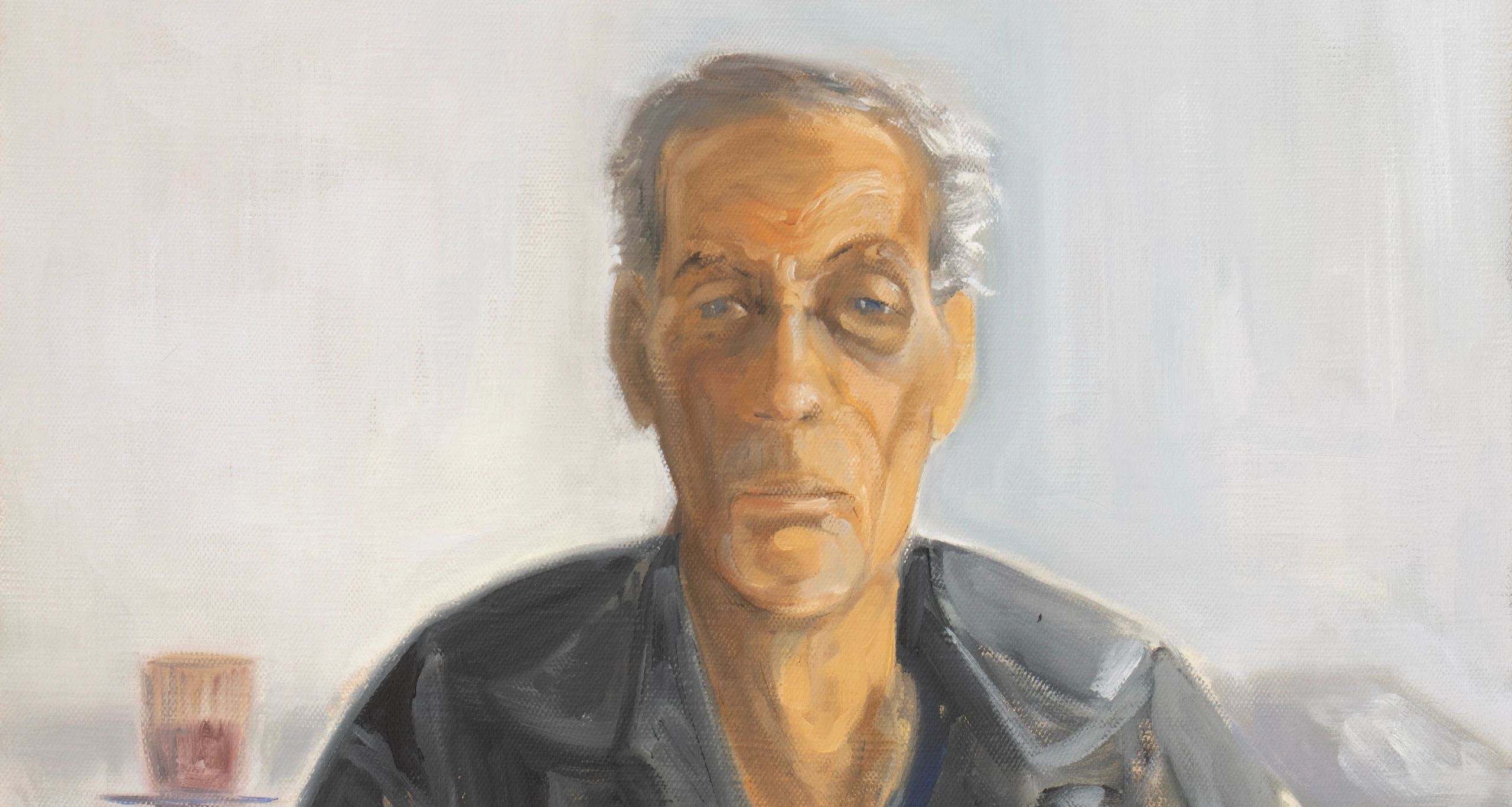 Portrait of a man in a dark shirt against a light background