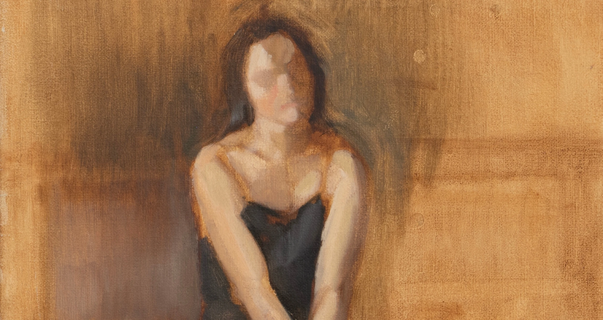Seated woman in a black dress against an ochre background