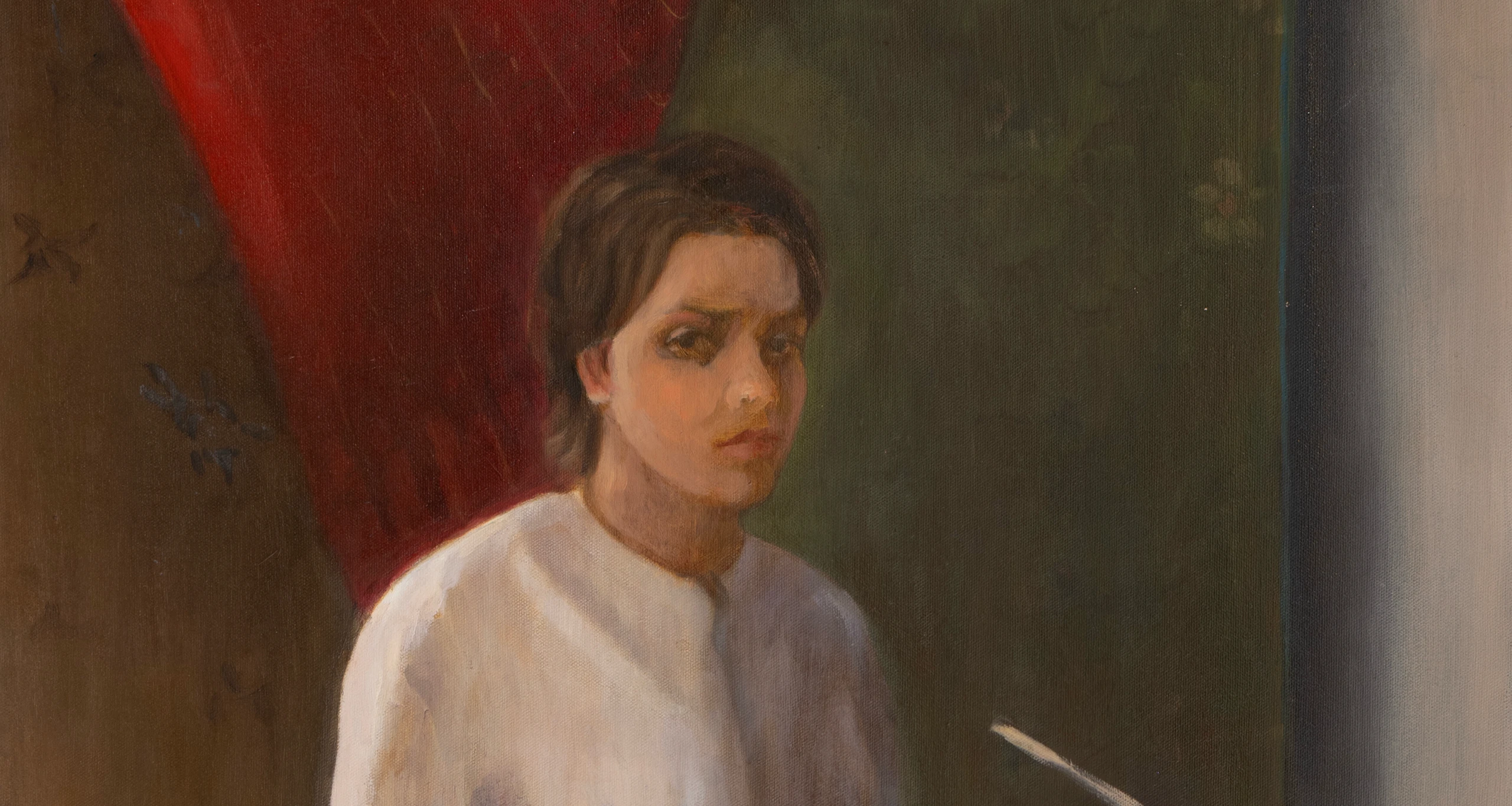 Portrait of a woman in a white shirt beside a red curtain