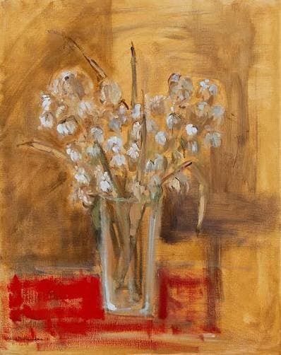 White flowers in a glass vase on a red cloth