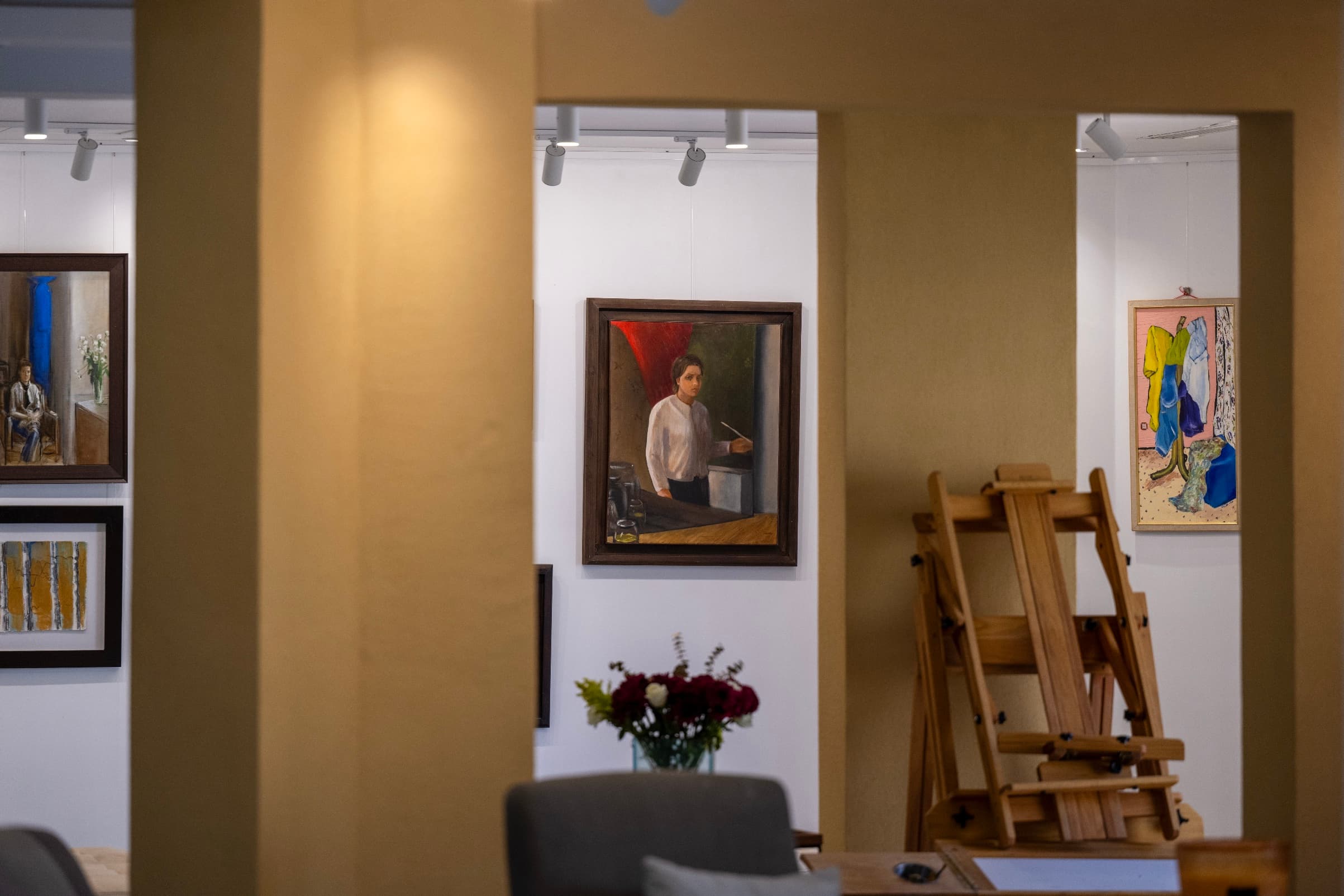 A sunlit art studio with paintings and art materials